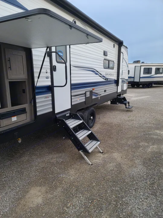 Springdale RV rental showing an outdoor kitchen, sturdy steps, and gravel lot.. Keystone Springdale 2021