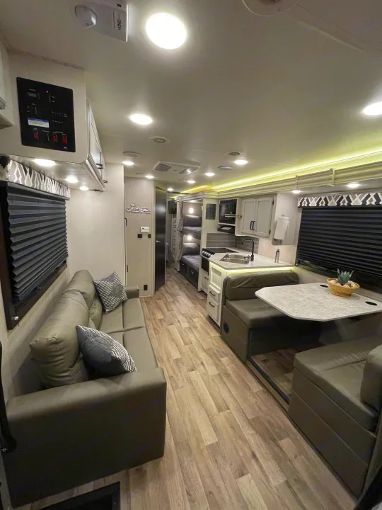 Spacious RV rental interior featuring a modern kitchen, dinette, and sofa, perfect for comfortable travel.. Jayco Redhawk 2021