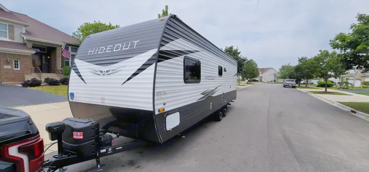 Newly sold Hideout travel trailer on suburban street, similar to popular RV rental units.. Keystone Hideout 2021
