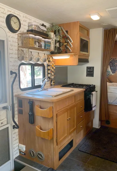 Cozy RV rental interior featuring a well-organized kitchen with a sink, stove, and smart storage solutions for cooking essentials.. Winnebago Chalet 2010