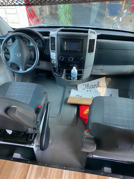 Spacious and clean RV rental van interior, showing the driver's cockpit with dashboard, steering wheel, and front seats.. Coachmen Prism 2016
