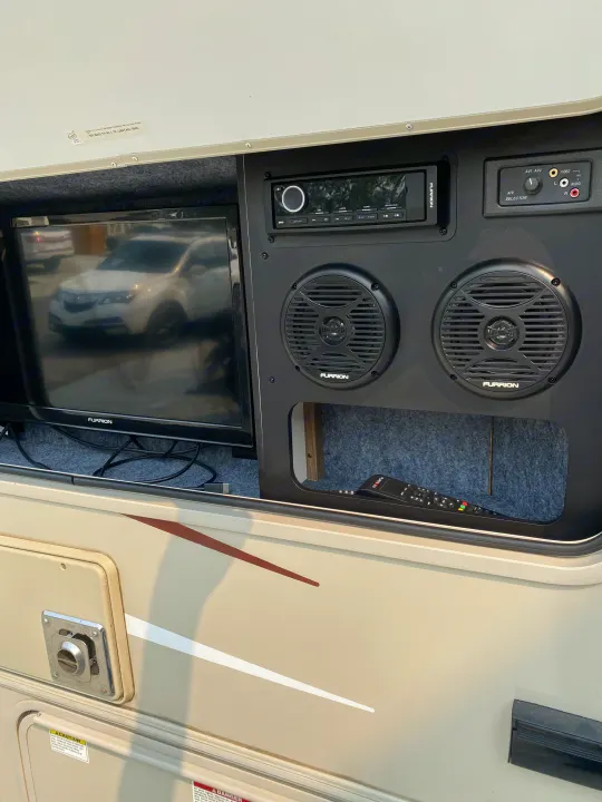 RV rental outdoor entertainment setup: Furrion TV, stereo, speakers, and remote in a dedicated compartment.. Coachmen Prism 2016