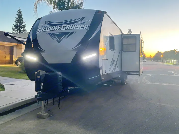 Brightly lit Shadow Cruiser travel trailer parked on a street at sunset. Consider this RV rental for your next adventure!. Cruiser Rv Corp Shadow Cruiser 2020