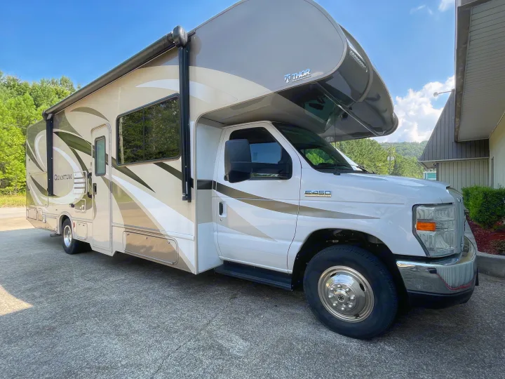 White and beige Thor Quantum Class C rv rental with green accents. This Ford E-450 motorhome is parked on asphalt.. Thor Motor Coach Other 2018