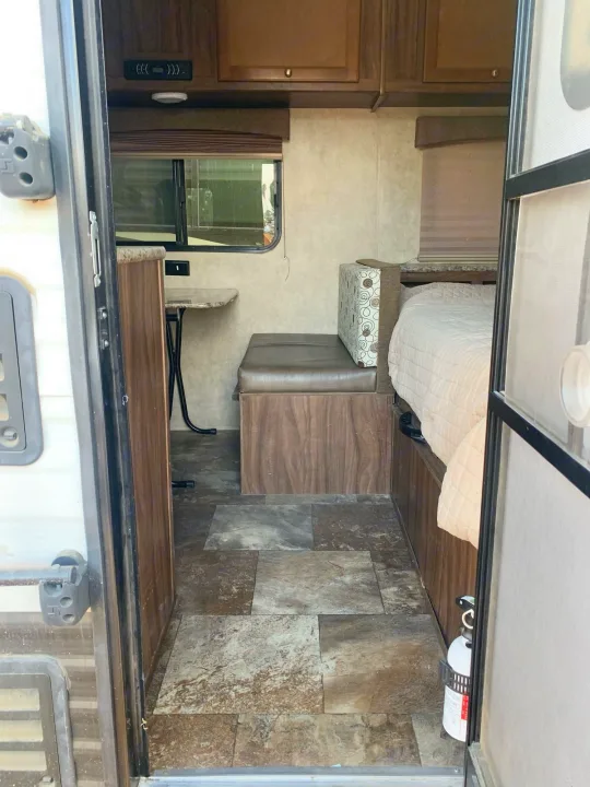 RV rental interior: view of compact dinette, window, and cozy bed. Fire extinguisher visible.. Coachmen Clipper 2015