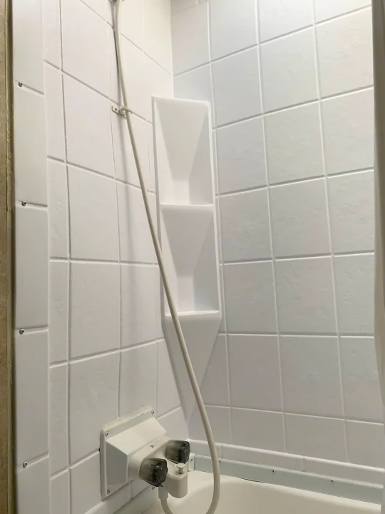 This RV rental features a bright, clean white shower with molded tile-like walls, a corner caddy, and a simple faucet.. Coachmen Clipper 2015