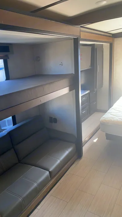 Spacious RV rental interior features comfortable bunk beds, a cozy sofa, and a separate bedroom area.. Forest River Other 2020