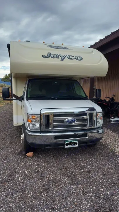 White Jayco Class C rv rental, a Ford motorhome, shown from front on a gravel lot under cloudy skies.. Jayco Redhawk 2016