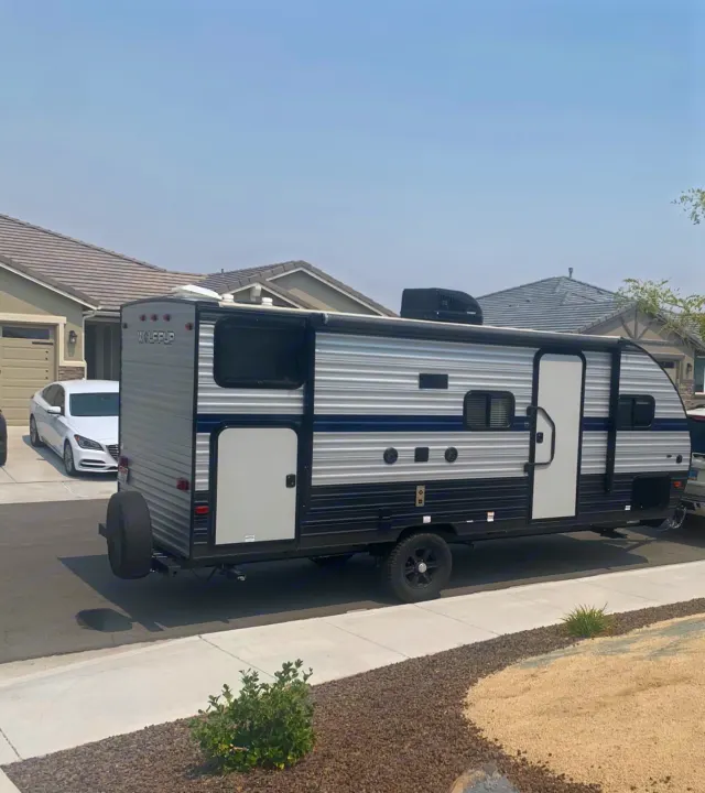 RV rental: A modern grey and black Wolf Pup travel trailer is parked on a suburban street.. Forest River Wolf Pup 2020