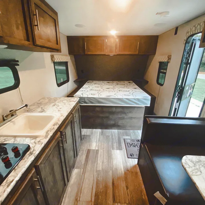Inside an RV rental: compact kitchen, cozy bedroom, and dinette area perfect for travel.. K-Z Manufacturing Sportsman Classic 2021