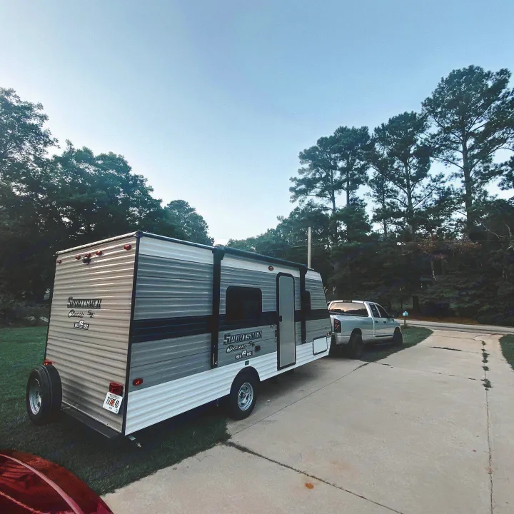 RV rental: A Sportsmen Classic SE camper trailer hitched to a pickup truck on a drive, ready for outdoor adventures.. K-Z Manufacturing Sportsman Classic 2021