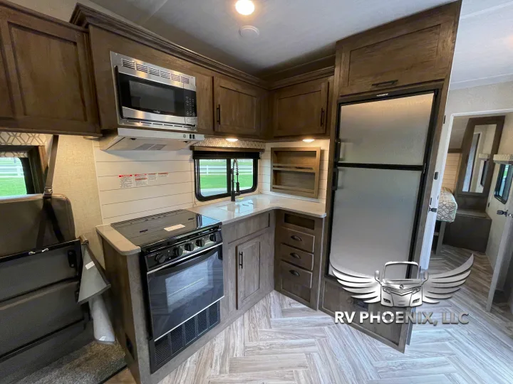 RV rental kitchen: modern interior with microwave, oven, fridge, and ample counter space for comfortable living.. Forest River Stealth 2021