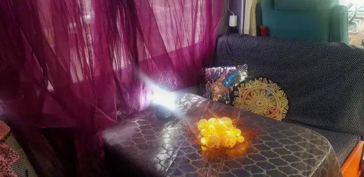 RV rental: Vibrant purple curtains, glowing decorative lights, patterned table, and a sequined pillow create a cozy space.. Chevrolet Other 1980
