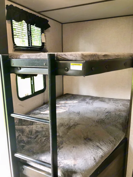 RV rental interior: cozy bunk beds with fuzzy blankets & windows. Max 300 lbs. capacity shown on top bunk.. Coleman Other 2021