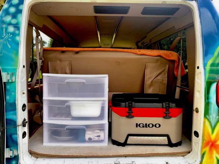 Rear view of RV rental van's organized interior: clear drawers with kitchenware & an Igloo cooler.. Dodge Ram 1500 1999
