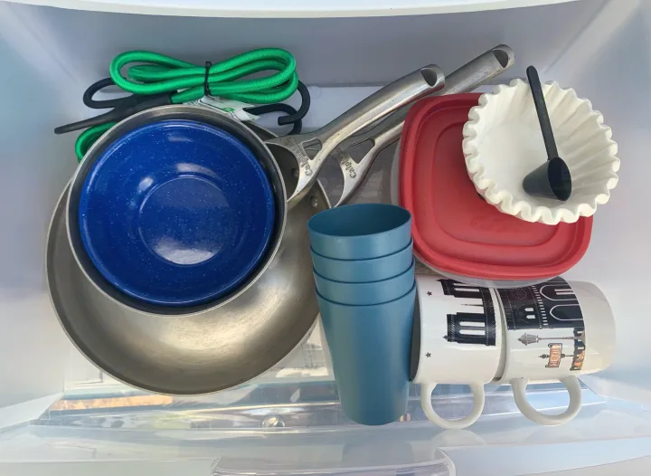 RV rental ready: clear bin packed with camping kitchen cookware, blue bowls, cups, coffee filter, & travel mugs.. Dodge Ram 1500 1999