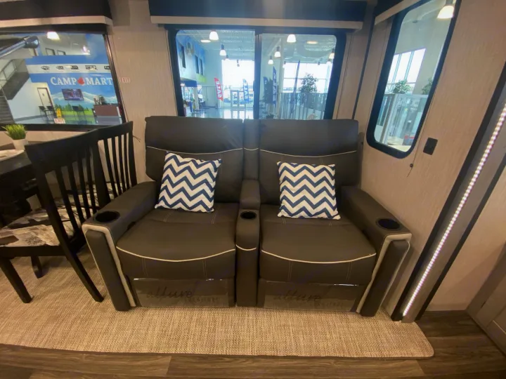 Relax in this RV rental's comfortable theater seating. Plush recliners, cup holders, and stylish pillows define the living space.. Heartland RVs Mallard 2021
