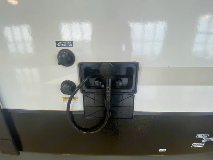 RV rental utility connections: city water port, outdoor shower, and sewer/waste tank labels. Essential for travel.. Heartland RVs Mallard 2021