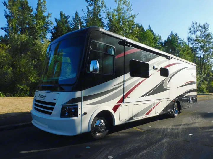 Modern Pursuit by Coachmen rv rental, white/black with red accents, parked in sun on asphalt. Ready for adventure!. Coachmen Pursuit 2017