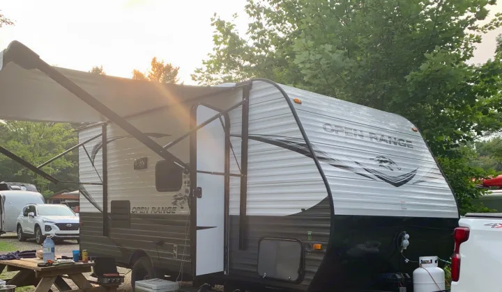 Enjoying a serene camping trip with an RV rental. This Open Range travel trailer features an extended awning, perfect for outdoor leisure.. Highland Ridge RV Open Range 2021