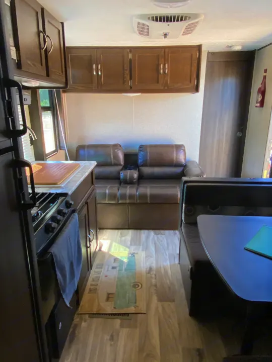 Explore this clean RV rental's interior, featuring a full kitchen, comfortable recliners, and a dining area.. Keystone Springdale 2018