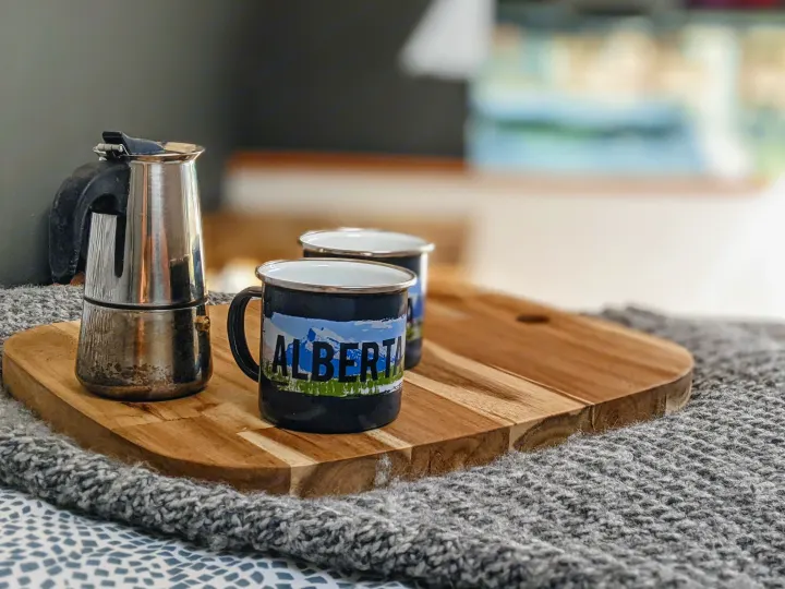Morning coffee in an RV rental! A moka pot and two "Alberta" mugs sit on a wooden tray on a cozy grey blanket.. Mercedes-Benz Mercedes Sprinter 2500 2015