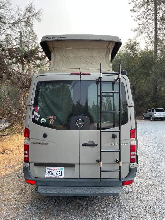 An rv rental Sprinter van featuring a pop-top roof and ladder, ideal for camping and outdoor adventures.. Sportsmobile Custom Design 2013