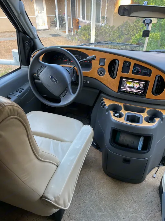 Inside a modern **rv rental**: a spacious cockpit with a Ford dashboard, infotainment system, and comfortable driver's seat.. Concord Coachmen 2004