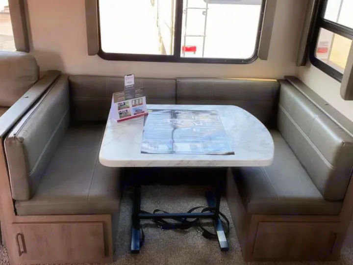 Cozy RV rental dinette with comfortable seating, a dining table, and built-in storage. Ideal for meals and relaxation.. Grand Design Other 2021