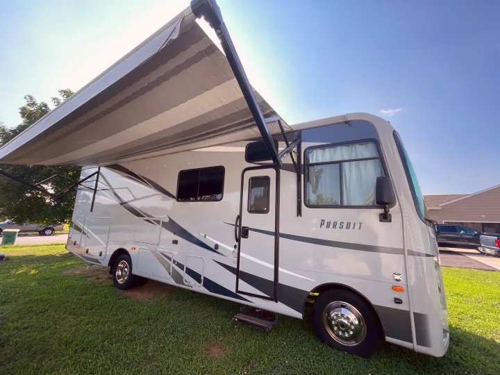 Spacious Pursuit motorhome with extended awning on a sunny day. Ideal RV rental for your next trip!. Coachmen Pursuit 2021