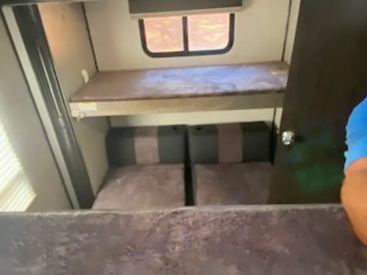 RV rental's cozy bunk beds: upper bunk with window, lower convertible seating for extra sleeping space.. Heartland RVs North Trail 2020