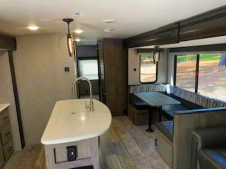 Spacious RV rental interior features a modern kitchen island with sink and a comfortable dinette.. Heartland RVs North Trail 2020