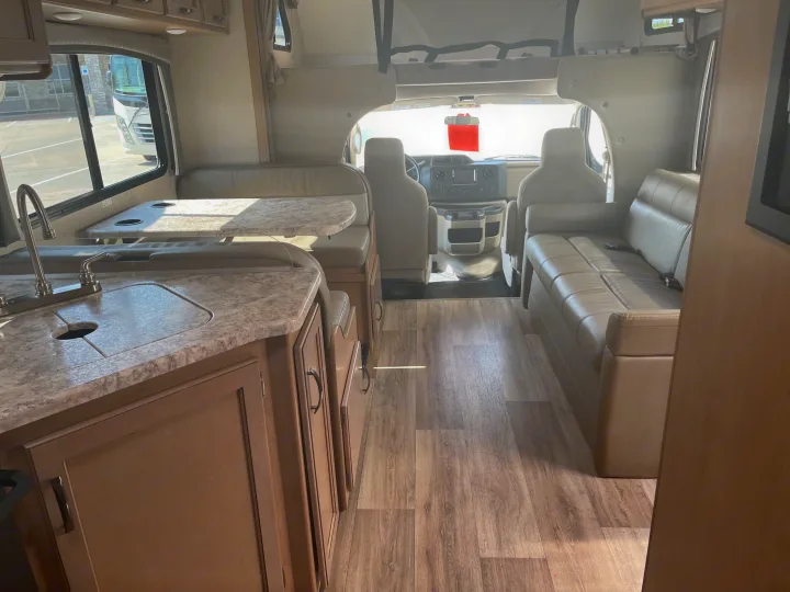 Explore the spacious interior of this RV rental, featuring a kitchen, dinette, sofa living area, and front cabin.. Thor Four Winds 2021