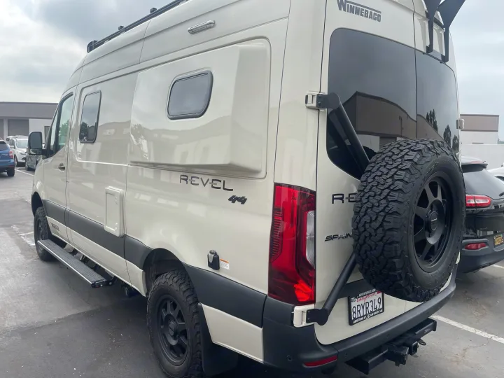 Cream Winnebago Revel camper van (RV rental) with off-road tires & rear spare. Ready for adventure.. Winnebago Revel 2021