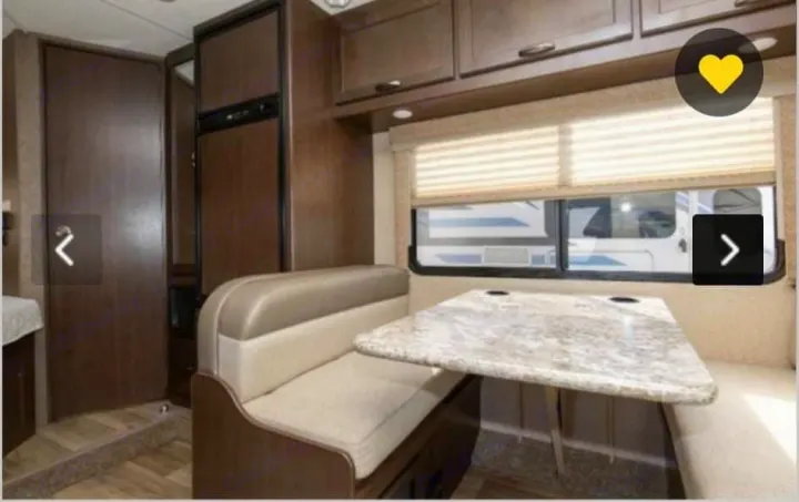 Inside this RV rental: A spacious dinette with comfortable bench seating & large table. Ideal for dining and relaxing on the road.. Thor Freedom Elite 2018