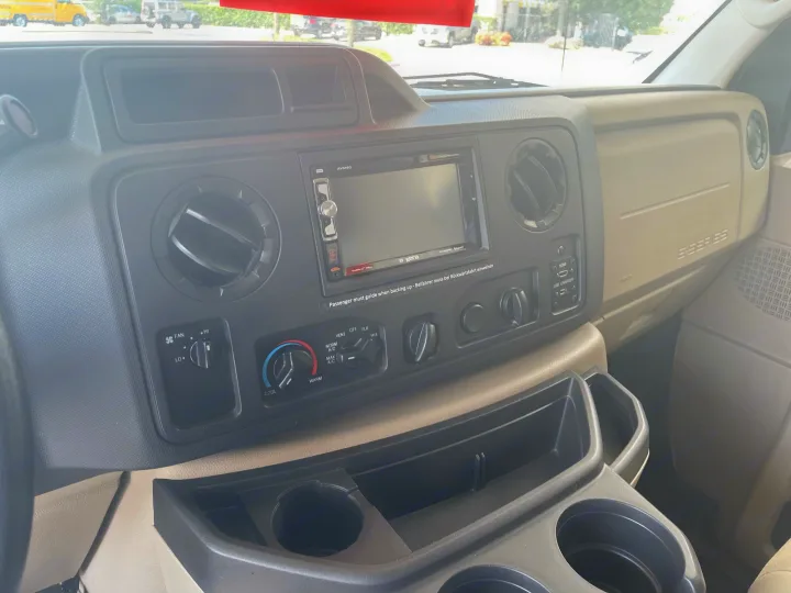 RV rental interior showing a Ford E-Series dashboard with infotainment screen, climate controls, and handy cup holders.. Thor Four Winds 2021
