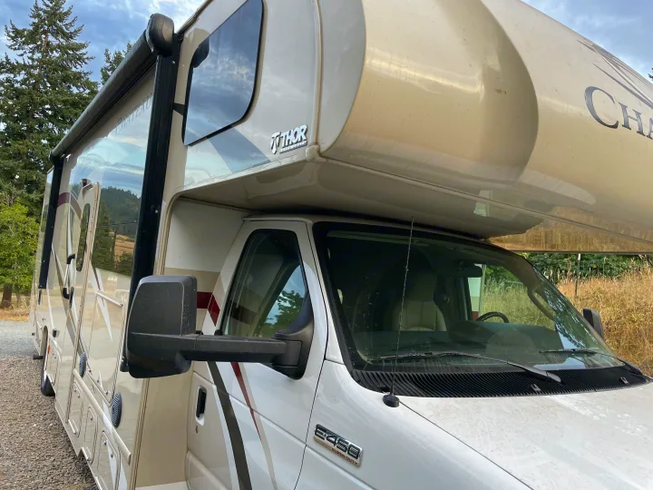 Side view of a white Thor Chateau Class C RV rental, built on a Ford E-450 Super Duty chassis, parked outdoors.. Thor Motor Coach Chateau 2017
