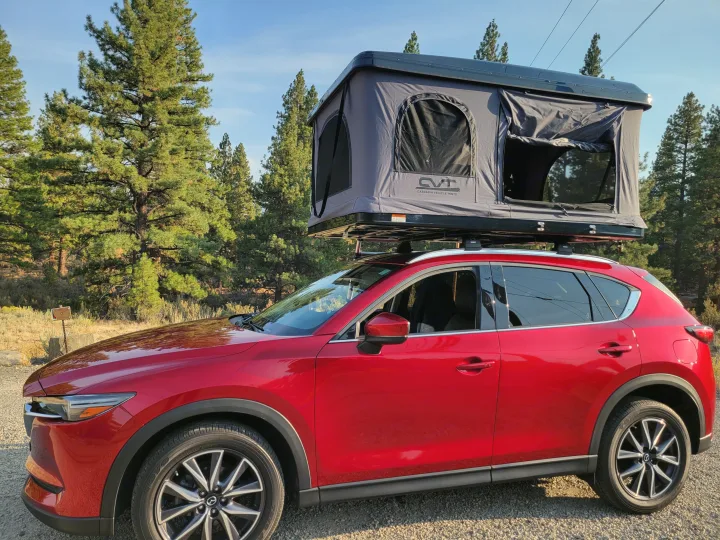 A red Mazda CX-5 SUV with a grey rooftop tent, perfect for outdoor camping adventures or an alternative to an RV rental.. Mazda Campervan 2018