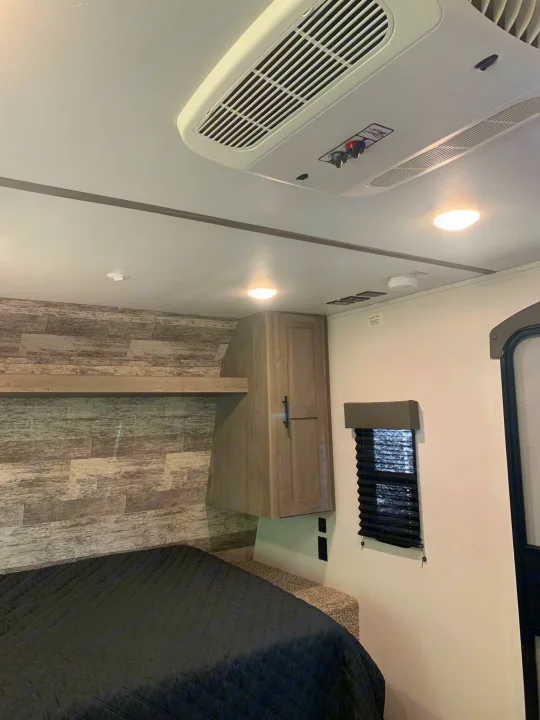 Inside this cozy RV rental bedroom: air conditioning, a comfortable bed, and modern interior finishes for your travels.. Keystone Springdale 2021