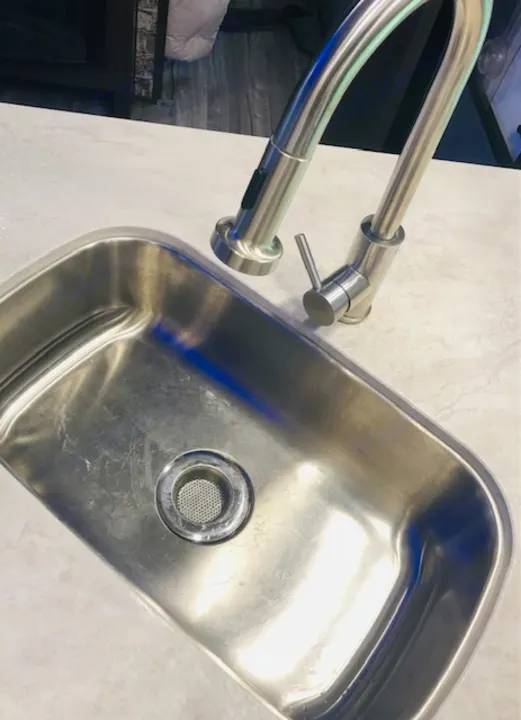 Sleek stainless steel kitchen sink and gooseneck faucet in an RV rental, with a light-colored countertop.. Forest River Cherokee Alpha Wolf 2018