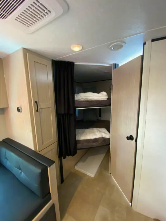 RV rental: Interior view of bunk beds with privacy curtains, overhead cabinets, and ceiling vent.. Coachmen Other 2021