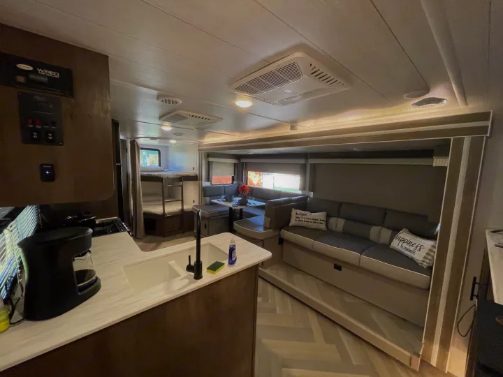 Spacious RV rental interior featuring a kitchen, cozy dinette, and living area with bunk beds. Ideal for travel.. Forest River Salem Cruise Lite 2022