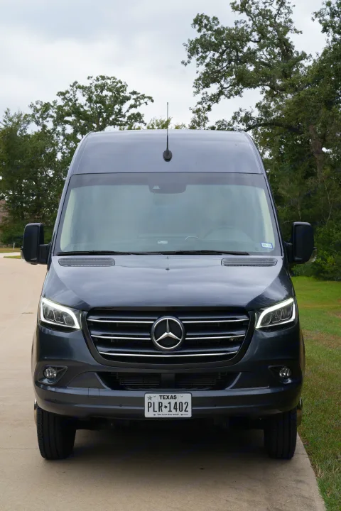Dark grey Mercedes-Benz Sprinter van, front view, ideal for rv rental travel. Parked on concrete driveway with trees.. Ultimate Toys Ultimate Traveler 2022