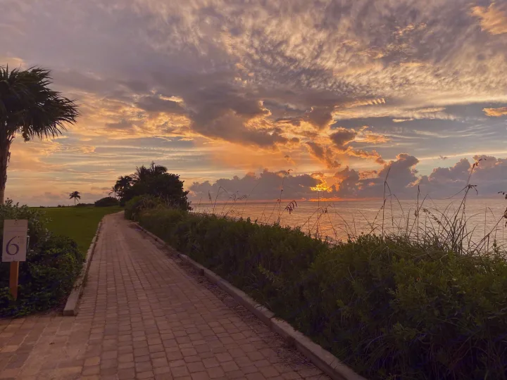 Golden hour by the sea: a picturesque paved path leads to the ocean, bathed in stunning sunset colors, ideal for an RV rental trip.. Foretravel U-320 2001
