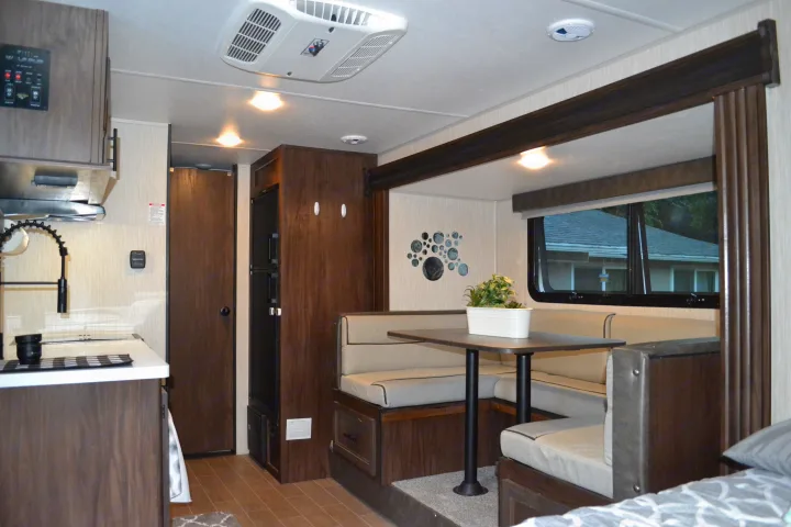 Modern RV rental interior with a bright kitchen, comfortable dinette, and ample living space, featuring an overhead AC unit.. Forest River Cherokee Wolf Pup 2020