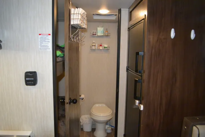 This RV rental offers a compact, efficient interior with a functional bathroom, toilet, and fridge, optimizing space.. Forest River Cherokee Wolf Pup 2020