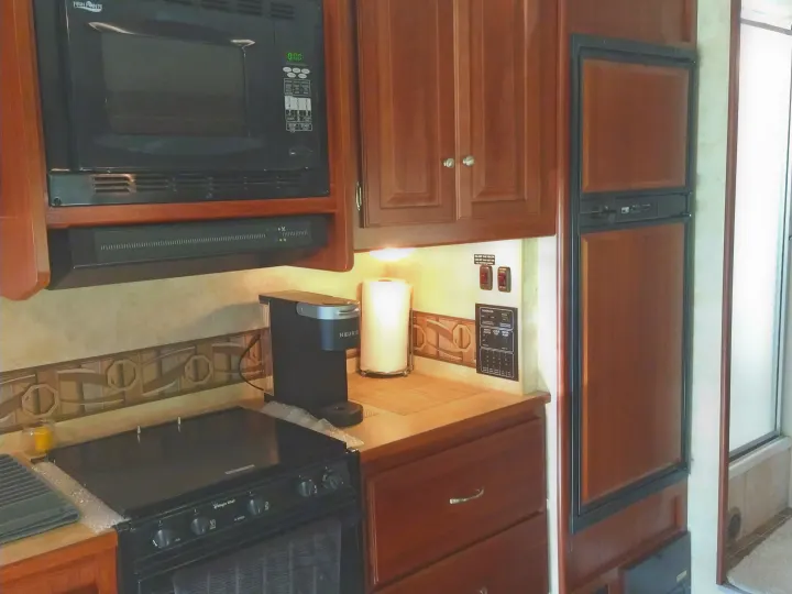RV rental kitchen: High Pointe microwave, Magic Chef stove, Keurig coffee maker, and refrigerator.. Winnebago Access 2011