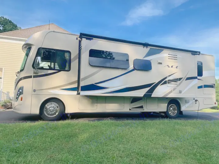 Beige Thor Motor Coach ACE Class A RV on a driveway, ideal for rv rental vacations. Enjoy comfortable road trips!. Thor Motor Coach A.C.E 2017