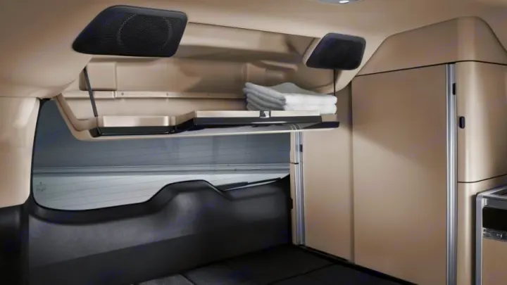 RV rental interior: beige ceiling, black speakers, a shelf with folded towels, and a tall cabinet for comfort on the road.. Mercedes Class V Marco Polo 2021