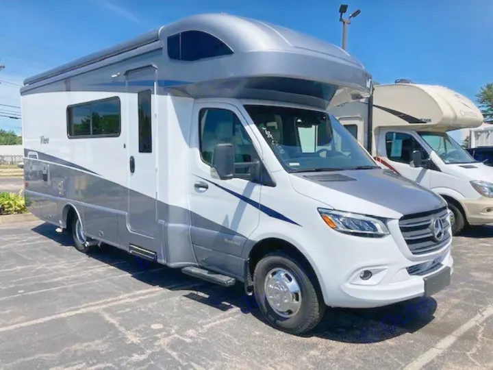 Modern white and gray Winnebago View RV rental, a Mercedes-Benz Sprinter model, parked outdoors on a sunny day.. Winnebago View 2021
